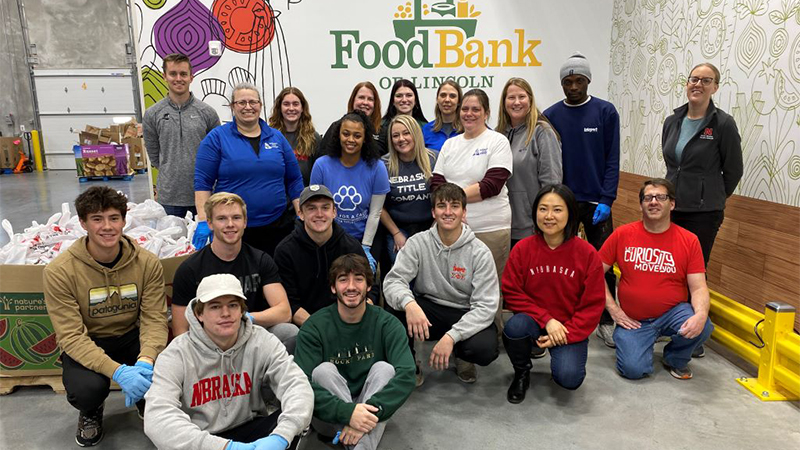 Students posing in front of a Food Bank banner.